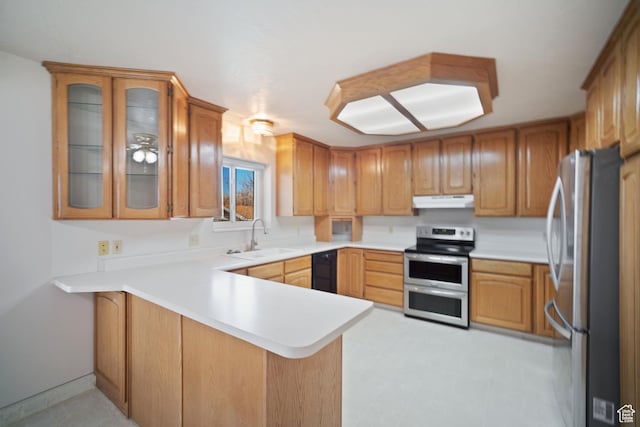 kitchen with light countertops, a peninsula, stainless steel appliances, under cabinet range hood, and a sink