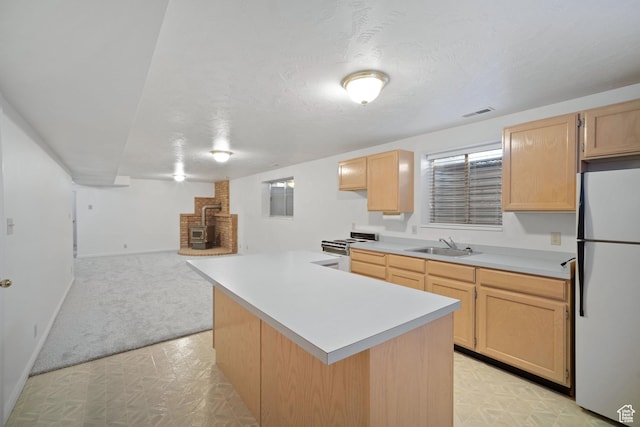 kitchen with light countertops, a sink, a kitchen island, light brown cabinets, and white appliances