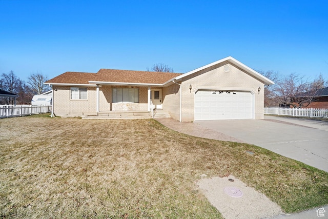 single story home featuring driveway, an attached garage, fence, brick siding, and a front lawn