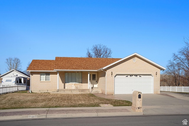 ranch-style house with brick siding, concrete driveway, fence, and an attached garage