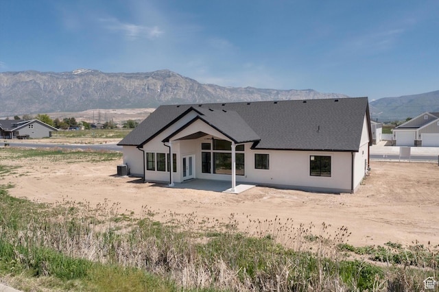 2833 N 3475 W, Plain City, UT 84404 - rear view of house featuring a mountain view, stucco siding, a shingled roof, cooling unit, and a patio area