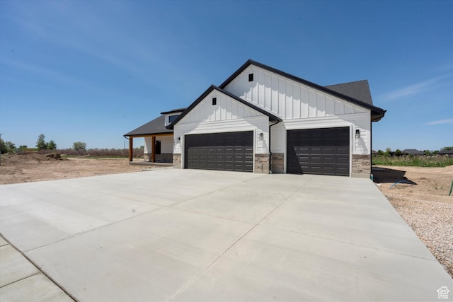 2833 N 3475 W, Plain City, UT 84404 - view of front of home with a garage, board and batten siding, stone siding, and concrete driveway