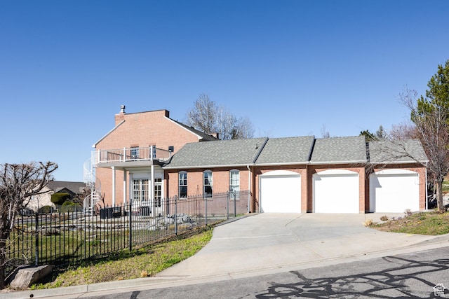 67 E Dorchester Dr, Salt Lake City, UT 84103 - view of front of house featuring brick siding, concrete driveway, a fenced front yard, and a balcony