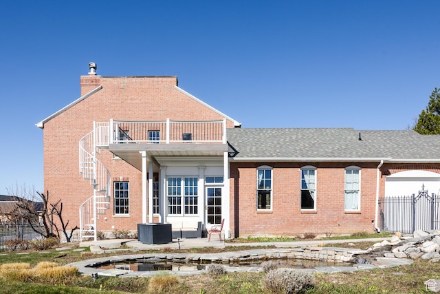 67 E Dorchester Dr, Salt Lake City, UT 84103 - rear view of property with a balcony, fence, stairway, brick siding, and roof with shingles
