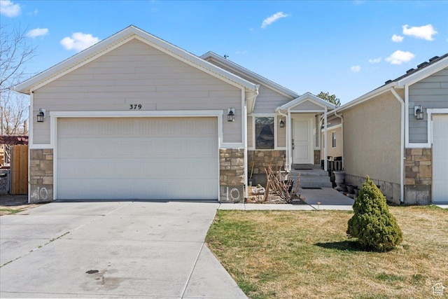 379 S Utah Dr, Grantsville, UT 84029 - view of front of home with stone siding, driveway, a garage, and a front lawn