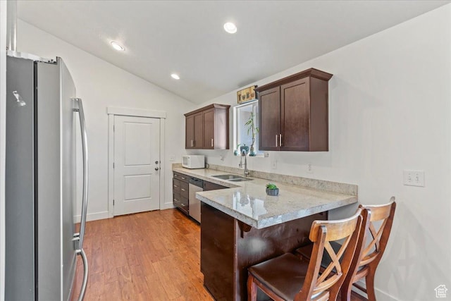 379 S Utah Dr, Grantsville, UT 84029 - kitchen with dark brown cabinetry, a sink, light wood finished floors, a peninsula, and stainless steel appliances