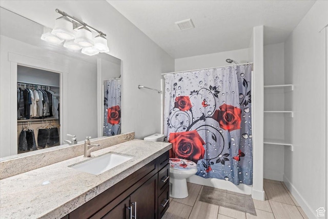 379 S Utah Dr, Grantsville, UT 84029 - bathroom with visible vents, baseboards, toilet, vanity, and a spacious closet