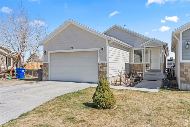 379 S Utah Dr, Grantsville, UT 84029 - view of front of property featuring stone siding, fence, a garage, concrete driveway, and a front lawn