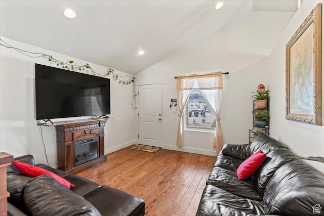 379 S Utah Dr, Grantsville, UT 84029 - living room with vaulted ceiling, light wood finished floors, a glass covered fireplace, baseboards, and recessed lighting