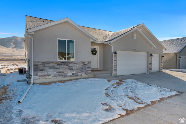 ranch-style house with stone siding, concrete driveway, stucco siding, and an attached garage