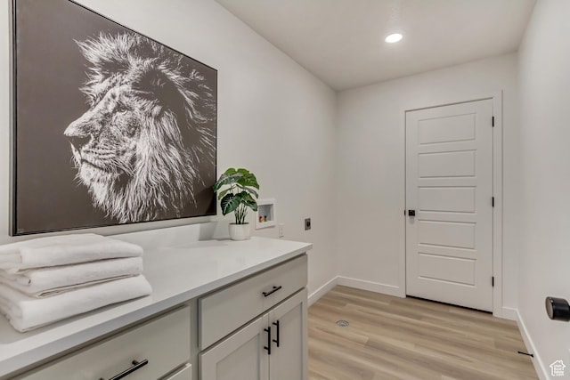 bathroom with recessed lighting, vanity, baseboards, and wood finished floors