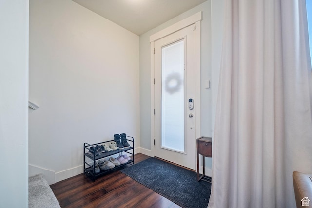 entrance foyer with dark wood-type flooring and baseboards