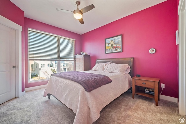 carpeted bedroom featuring baseboards and a ceiling fan