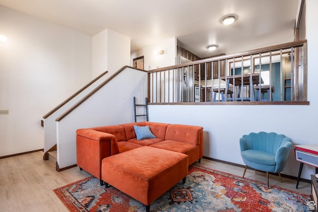 living area with baseboards and wood finished floors