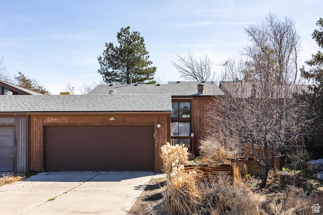view of front of house featuring concrete driveway, a shingled roof, and an attached garage