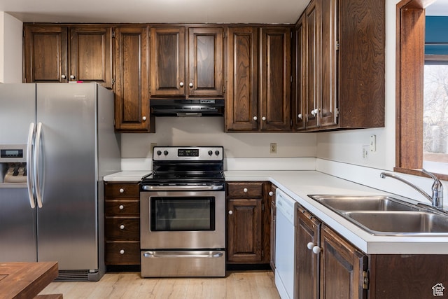 kitchen with a sink, stainless steel appliances, dark brown cabinets, and range hood