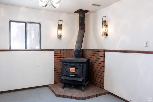 room details featuring visible vents, baseboards, and a wood stove