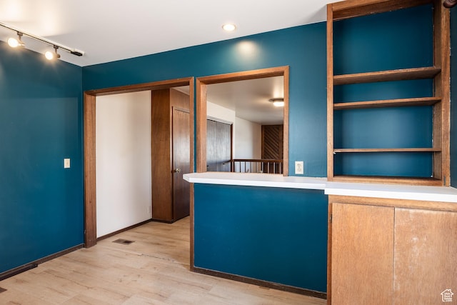 kitchen featuring baseboards, visible vents, and wood finished floors