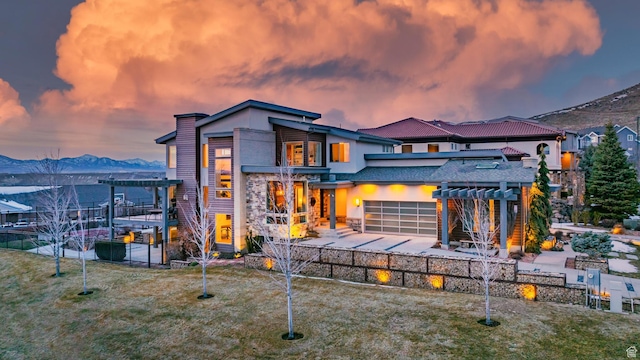 4601 N Toscana Hills Dr, Lehi, UT 84043 - back of property at dusk featuring a pergola, stucco siding, a mountain view, and a patio area