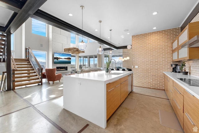4601 N Toscana Hills Dr, Lehi, UT 84043 - kitchen with light countertops, modern cabinets, black electric cooktop, brick wall, and finished concrete floors