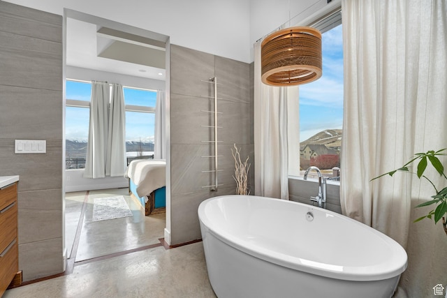 4601 N Toscana Hills Dr, Lehi, UT 84043 - ensuite bathroom featuring a freestanding tub, concrete floors, connected bathroom, and vanity