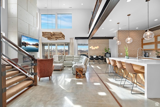 4601 N Toscana Hills Dr, Lehi, UT 84043 - living area featuring finished concrete flooring, stairs, a high ceiling, and recessed lighting
