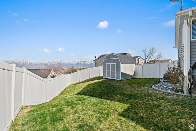 6874 S Hoyle Cir, West Jordan, UT 84081 - view of yard featuring a storage unit, a fenced backyard, an outdoor structure, and a mountain view