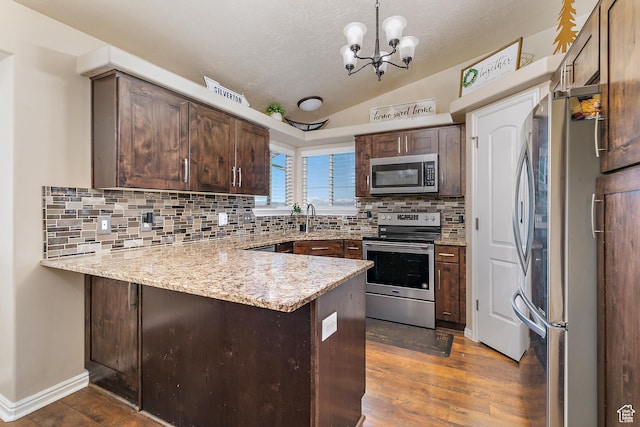6874 S Hoyle Cir, West Jordan, UT 84081 - kitchen with dark wood-style floors, vaulted ceiling, stainless steel appliances, and a peninsula