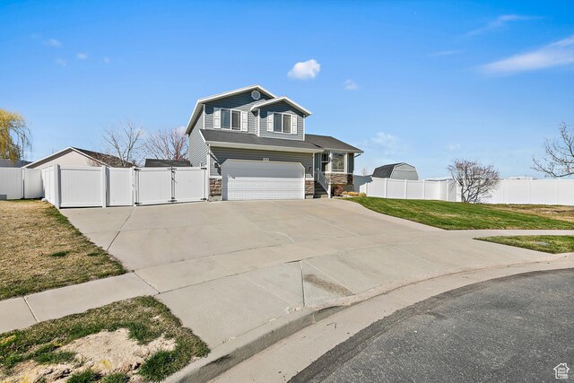 view of front of home with concrete driveway, fence, an attached garage, stone siding, and a gate