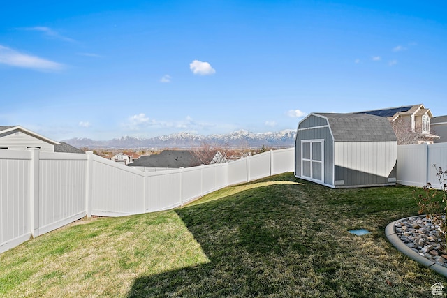 6874 S Hoyle Cir, West Jordan, UT 84081 - view of yard featuring a fenced backyard, an outbuilding, a storage unit, and a mountain view