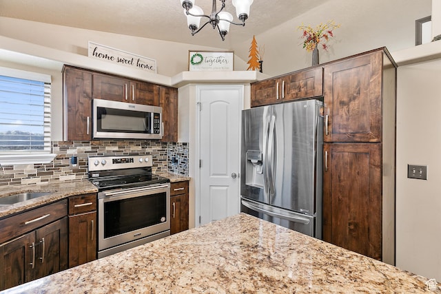 6874 S Hoyle Cir, West Jordan, UT 84081 - kitchen with decorative backsplash, a chandelier, light stone countertops, dark brown cabinets, and appliances with stainless steel finishes