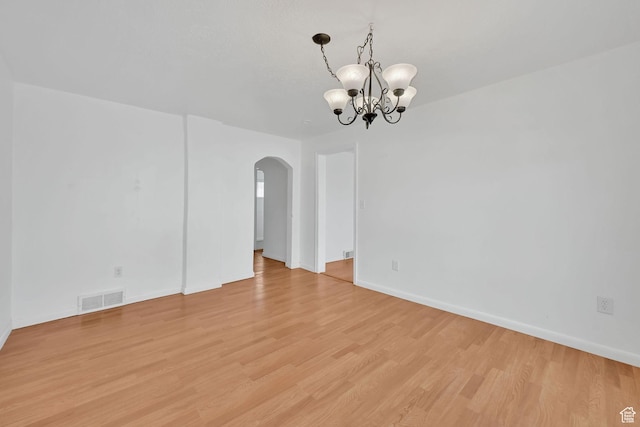 150 E 200 S, Providence, UT 84332 - empty room featuring baseboards, a chandelier, light wood-style floors, visible vents, and arched walkways