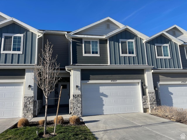 4937 E Lake Dr, Eagle Mountain, UT 84005 - view of front of home with driveway, stone siding, board and batten siding, and a garage