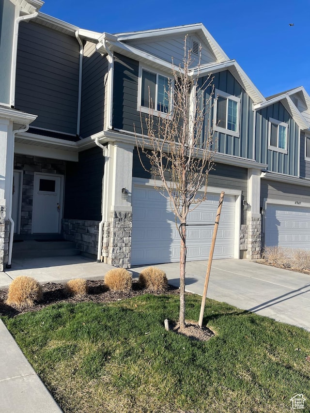 4937 E Lake Dr, Eagle Mountain, UT 84005 - view of front of home featuring stone siding, driveway, a garage, and board and batten siding
