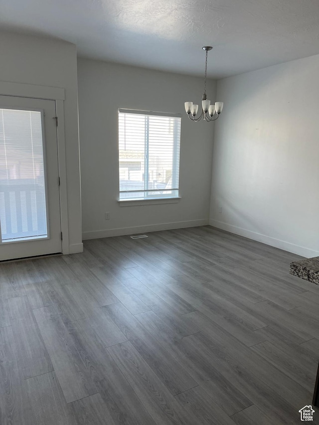 4937 E Lake Dr, Eagle Mountain, UT 84005 - unfurnished dining area with a notable chandelier, a textured ceiling, baseboards, and wood finished floors