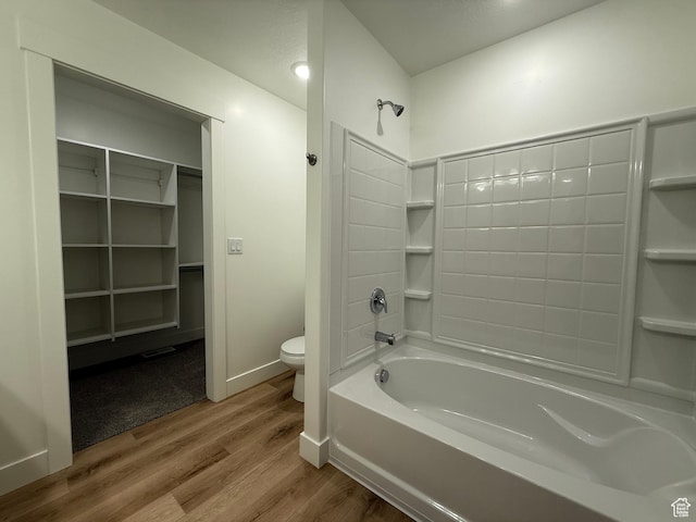 full bathroom with baseboards, toilet, shower / bath combination, and wood finished floors