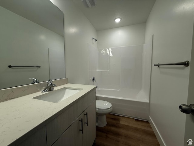 bathroom with toilet, vanity, shower / bathtub combination, wood finished floors, and visible vents