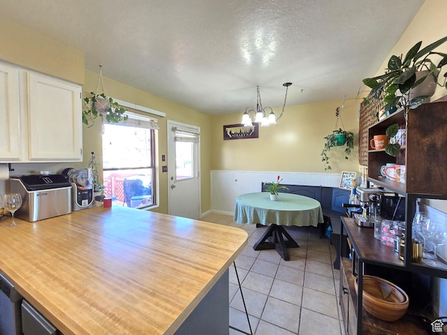 243 Downs Cir, Ogden, UT 84404 - kitchen featuring light tile patterned flooring, white cabinetry, a textured ceiling, a peninsula, and an inviting chandelier