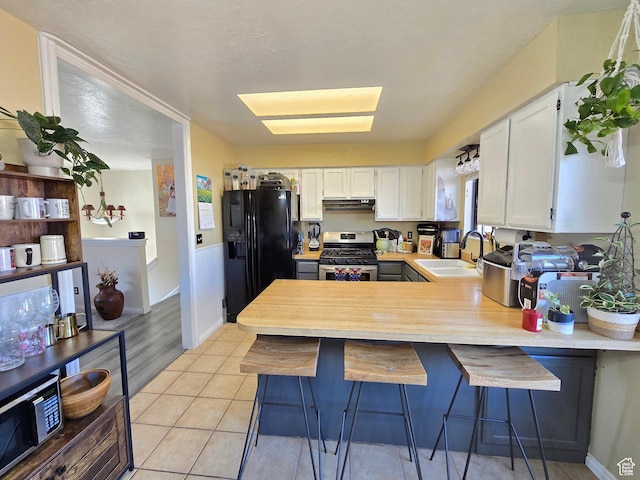 243 Downs Cir, Ogden, UT 84404 - kitchen featuring light countertops, black fridge with ice dispenser, under cabinet range hood, gas stove, and a sink