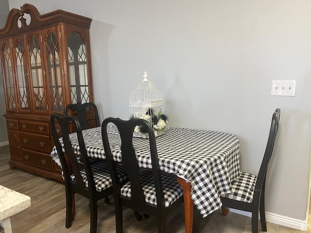 dining area featuring baseboards and light wood-style floors