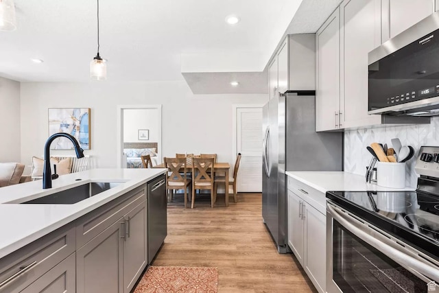 875 W Akoya Pearl St S Unit 101-B, St George, UT 84790 - kitchen with appliances with stainless steel finishes, gray cabinetry, a sink, light countertops, and light wood finished floors