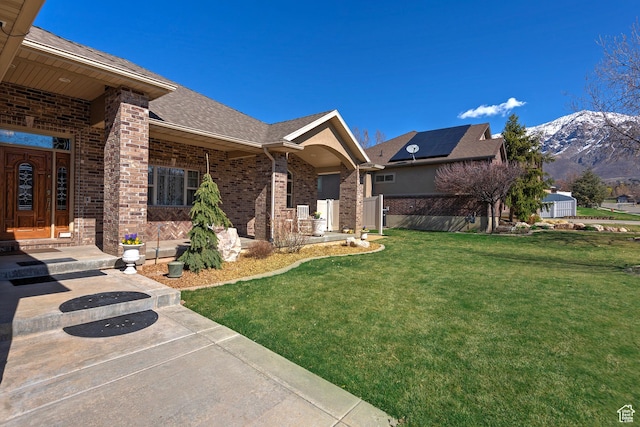 3173 N 1050 W, Pleasant View, UT 84414 - exterior space with a front lawn, a shingled roof, a mountain view, and brick siding