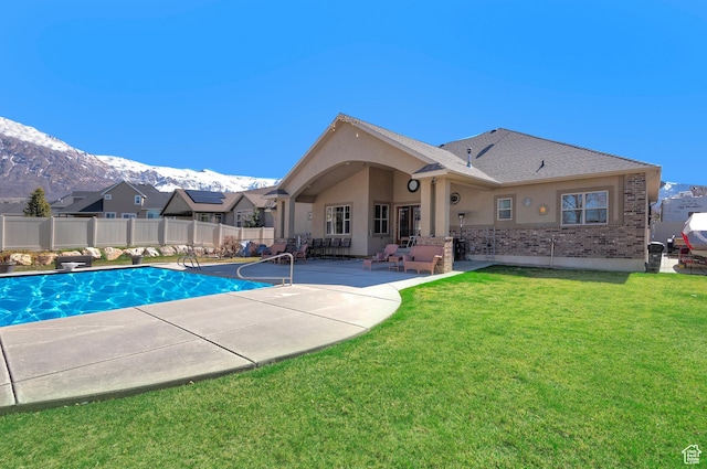 view of swimming pool featuring fence, a fenced in pool, a mountain view, a yard, and a patio area