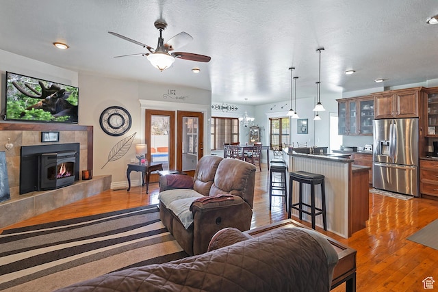 3173 N 1050 W, Pleasant View, UT 84414 - living room with a textured ceiling, baseboards, ceiling fan, light wood-type flooring, and french doors