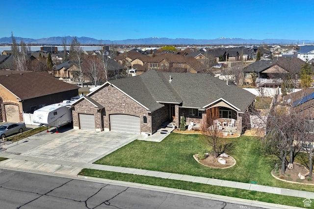 ranch-style house with an attached garage, a mountain view, concrete driveway, and a residential view