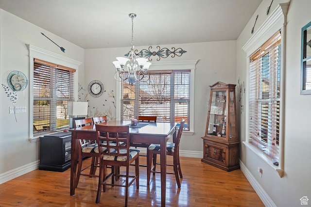 3173 N 1050 W, Pleasant View, UT 84414 - dining space with baseboards, wood finished floors, a healthy amount of sunlight, and a notable chandelier