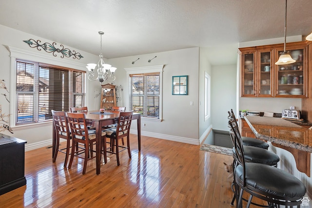 3173 N 1050 W, Pleasant View, UT 84414 - dining area with baseboards, a textured ceiling, light wood-style flooring, and a notable chandelier