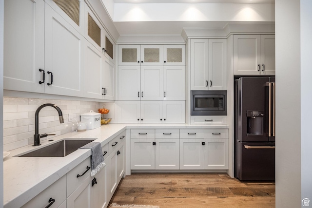1230 S Eaglenest Dr, Woodland Hills, UT 84653 - kitchen with black refrigerator with ice dispenser, built in microwave, a sink, light stone countertops, and light wood-type flooring
