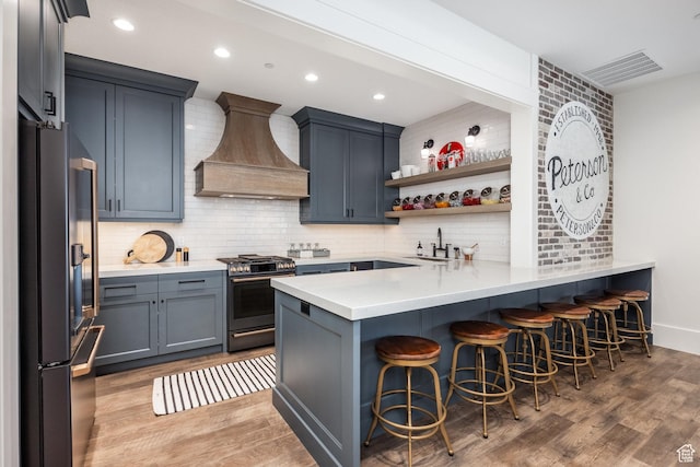 1230 S Eaglenest Dr, Woodland Hills, UT 84653 - kitchen featuring fridge, gas range, custom range hood, a peninsula, and a breakfast bar