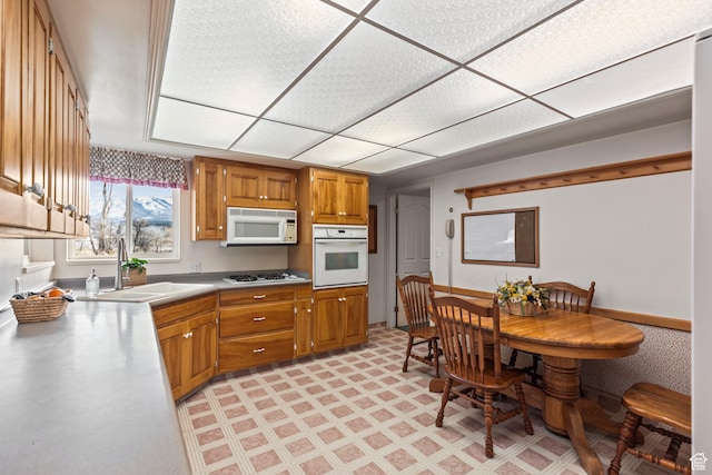 430 E Canyon Rd, Fillmore, UT 84631 - kitchen with a sink, light floors, brown cabinetry, white appliances, and stainless steel counters